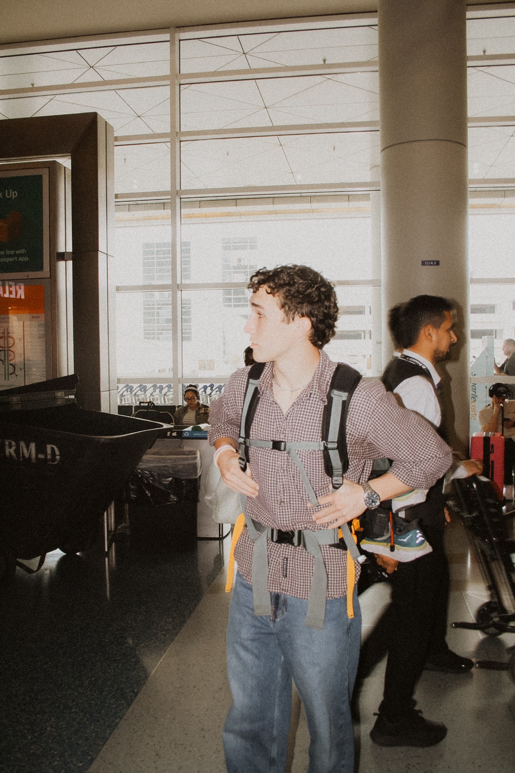 Founder at the airport with a backpack, captured in a cinematic documentary style