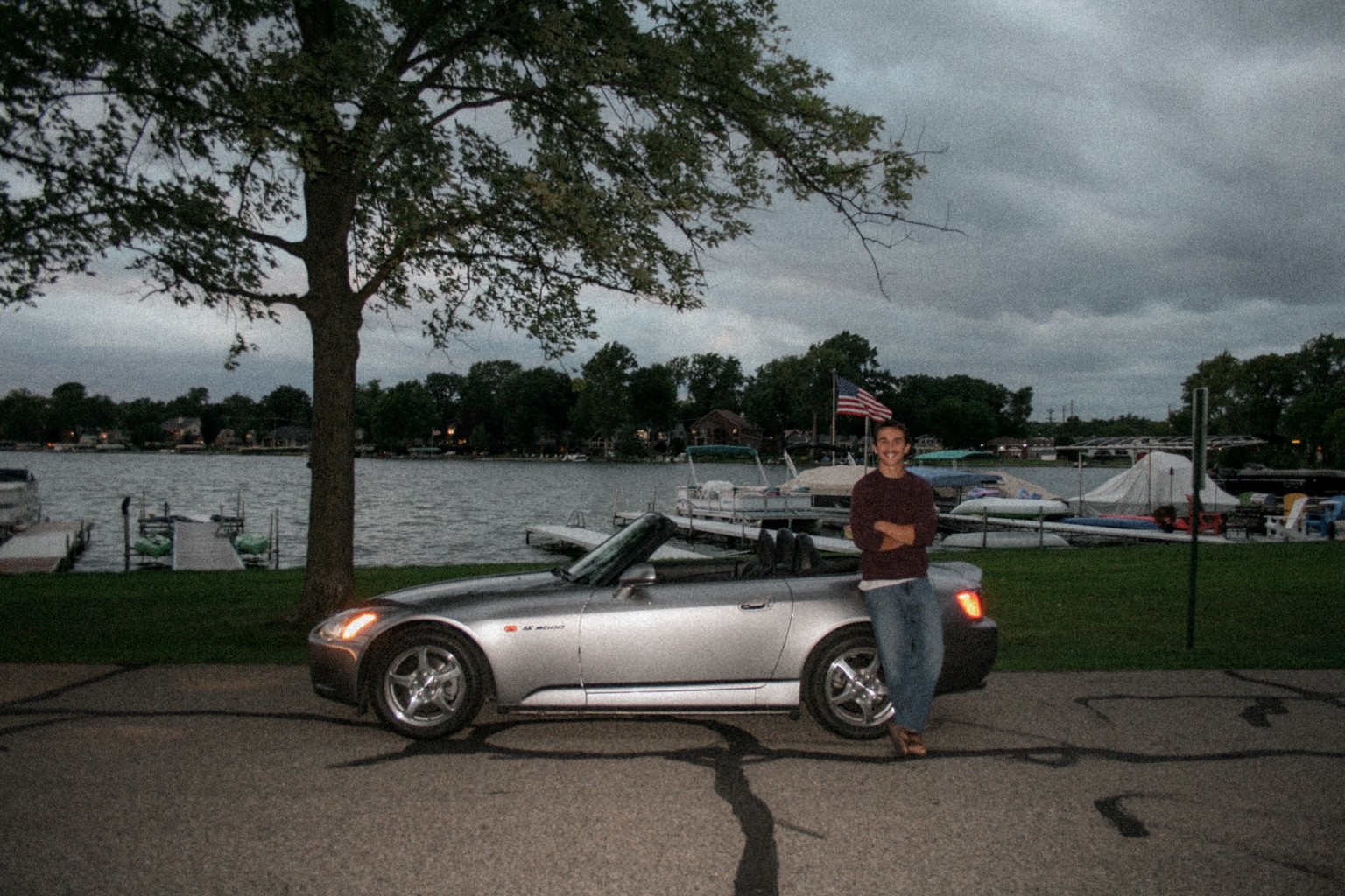 Founder beside a convertible by the water