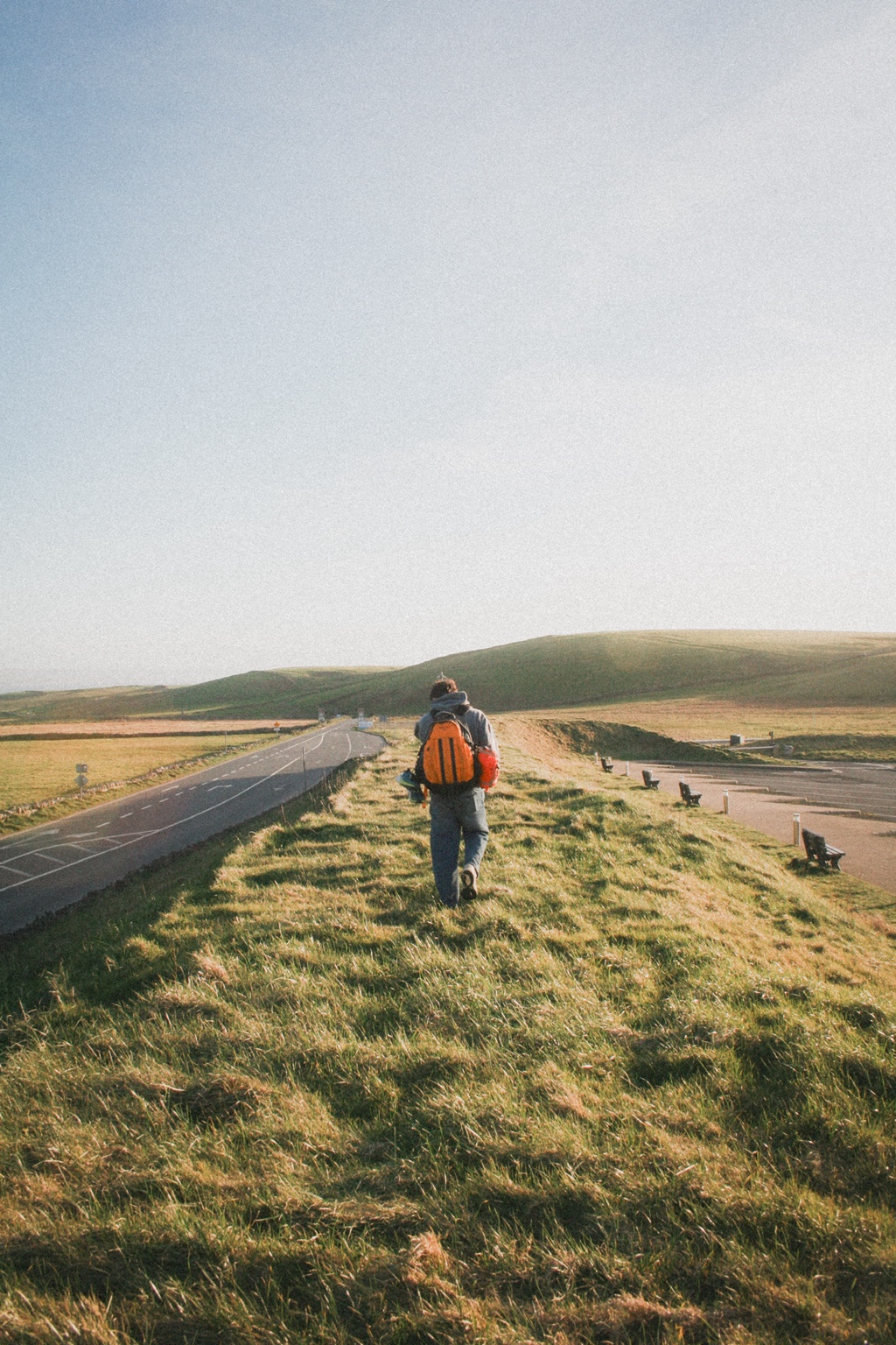 Walking down an open road with a backpack
